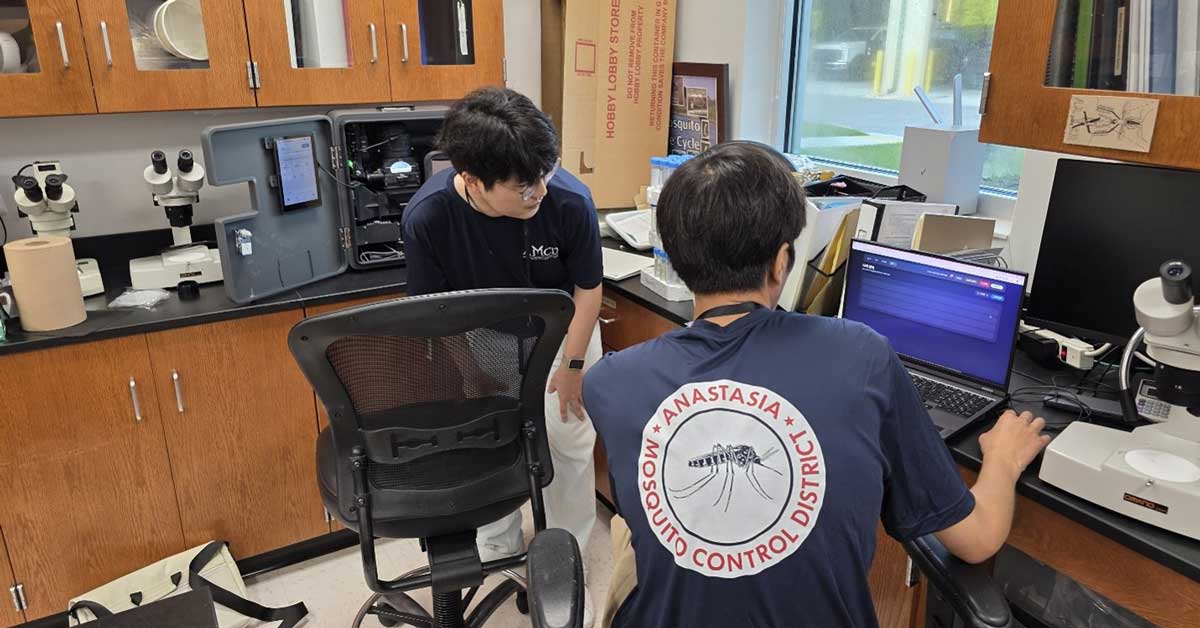 Two students in a lab using a laptop.