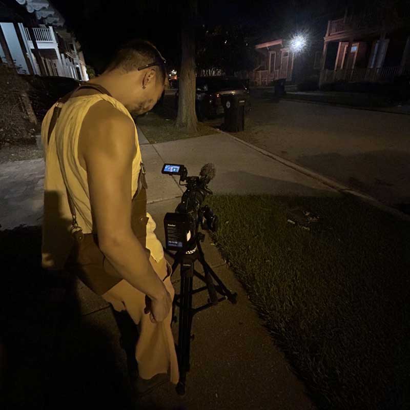 A student using a camera is recording rat activity in a trashcan at night.